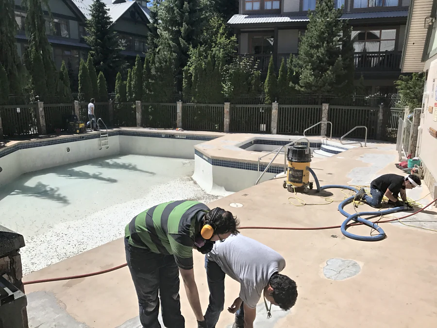 The crew preparing a hotel pool deck in Whistler round the drained pool and hot tub, grinding under dust extraction