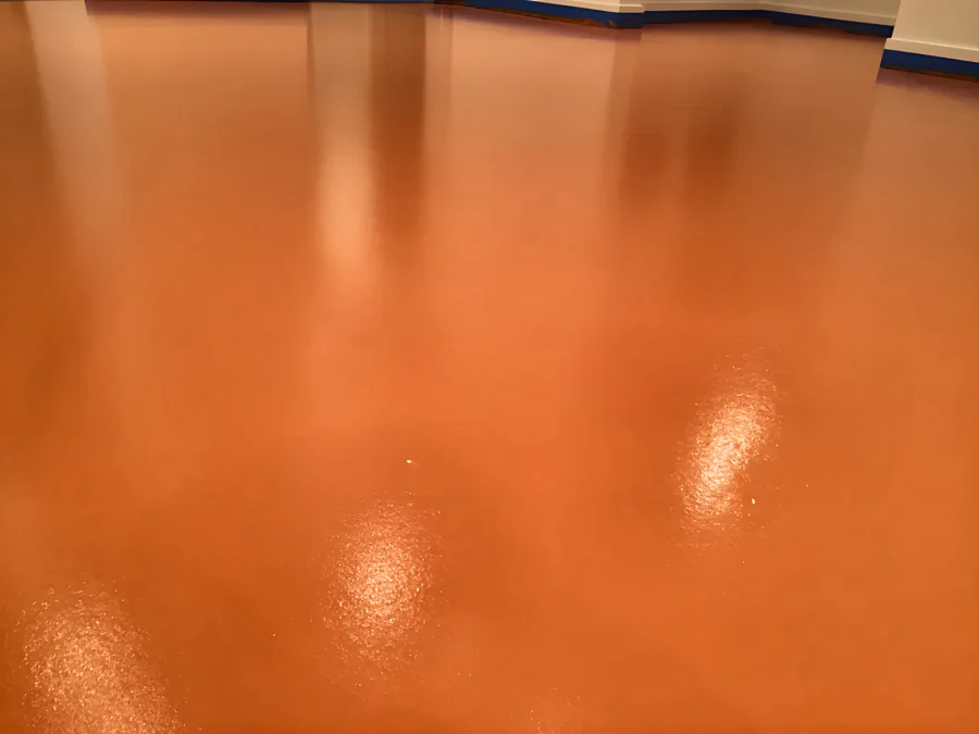 Close view of the pumpkin-orange urethane floor in Whistler, with the gloss and the fine texture of the finish in the light